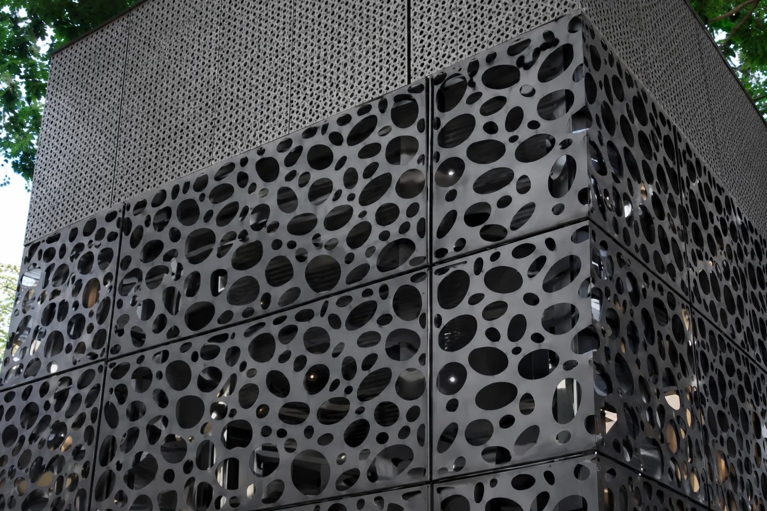 Fachada metálica con perforaciones orgánicas